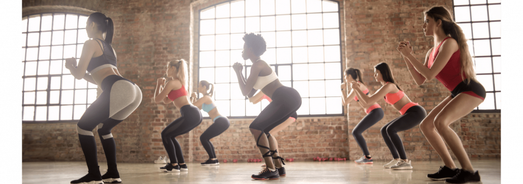 A group of ladies in a group exercise session with a female trainer